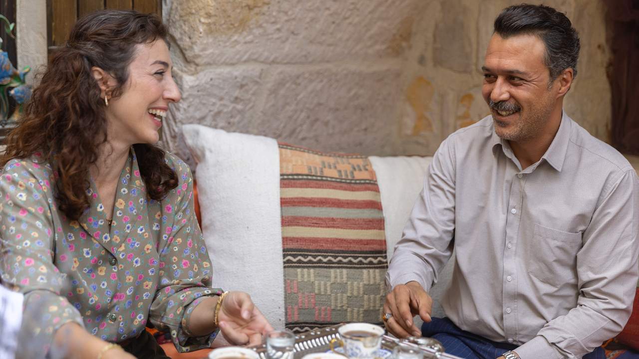 Anne Yarısı dizisinden bir sahne: çay eşliğinde gülerek sohbet eden bir kadın ve bir adam